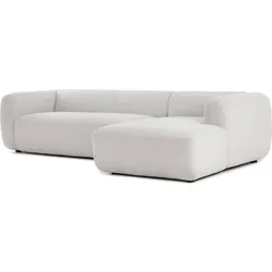 Modern minimalist L-shaped white sofa with rounded edges on a plain background