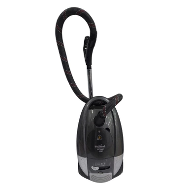 Grey canister vacuum cleaner with flexible black hose.